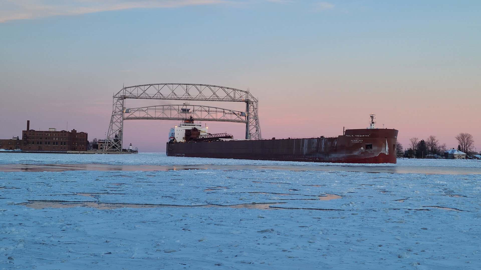 Ore ship passing the Aerial Lift Bridge amid harbor ice in Duluth, Minnesota