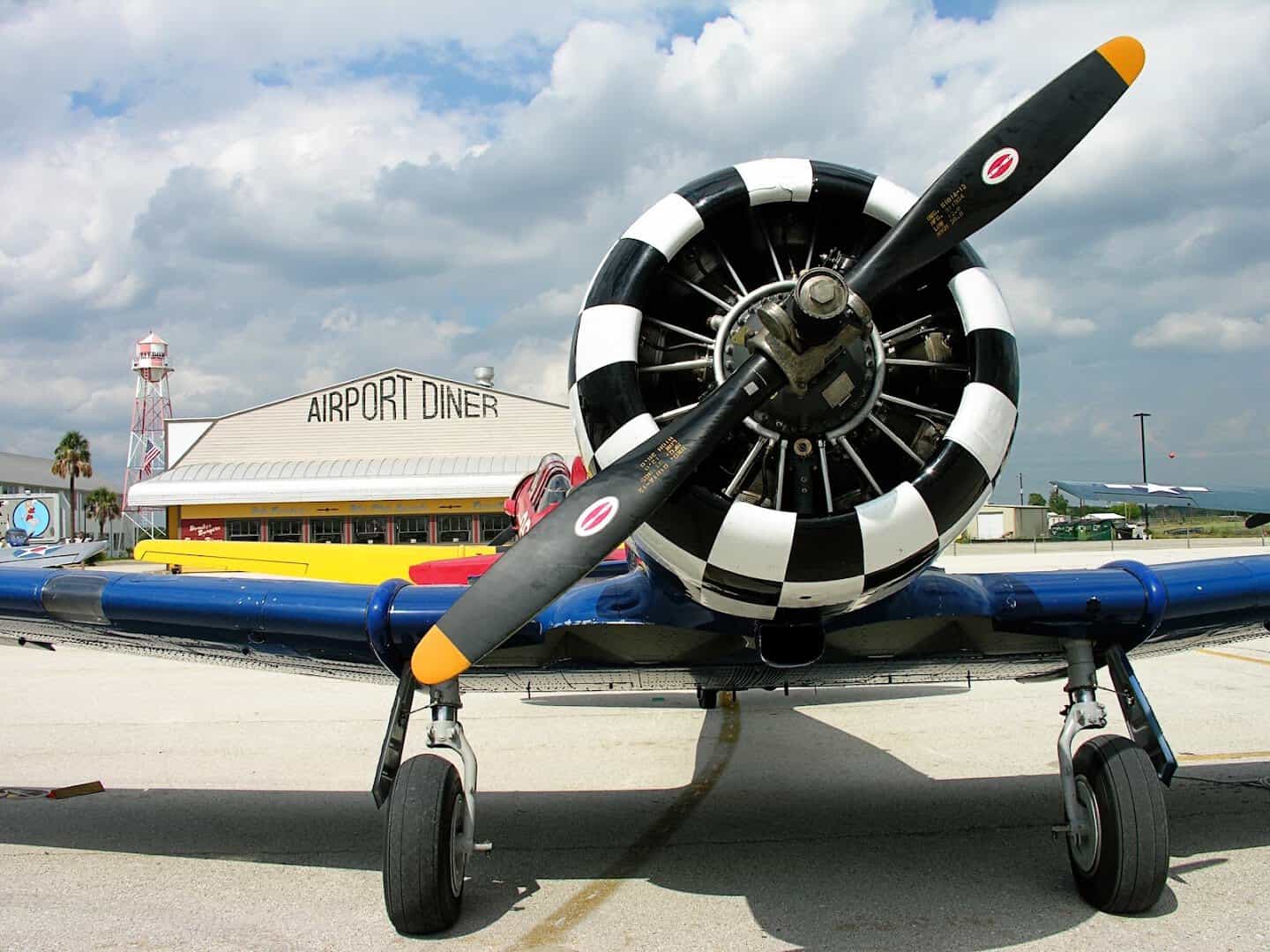 A vintage propeller plane parked in front of the Airport Diner in Fredericksburg, Texas
