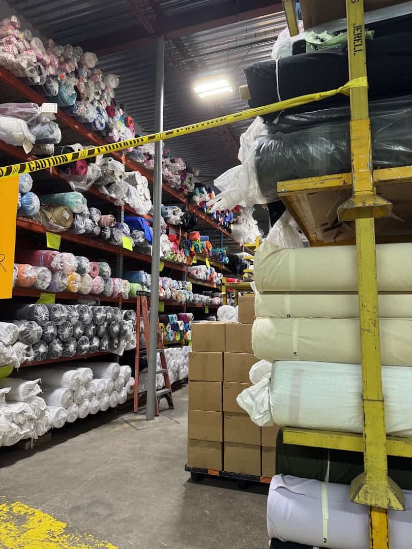 Aisle of fabric bolts on tall shelving at Wherehouse Fabrics in Dallas