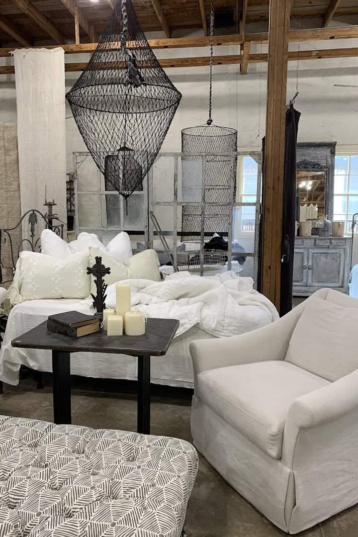 All white room with slipcovered sofas and a wire chandelier at Carol Hicks Bolton Antiques in Fredericksburg