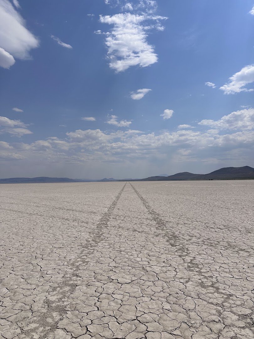 The cracked flat playa of the Alvord Desert stretching to distant mountains in southeast Oregon