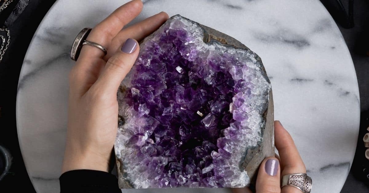 Hands holding an amethyst cluster from Nature's Treasures in Austin