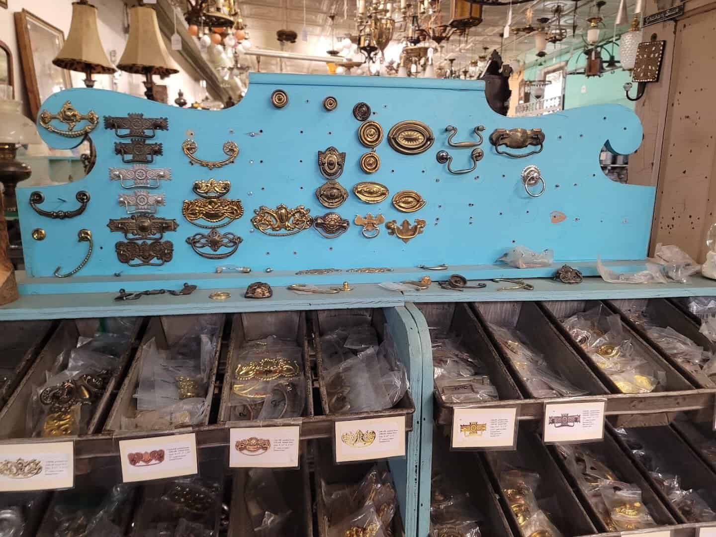 Antique brass drawer pulls and door hardware on display at Old Home Supply House in Fort Worth