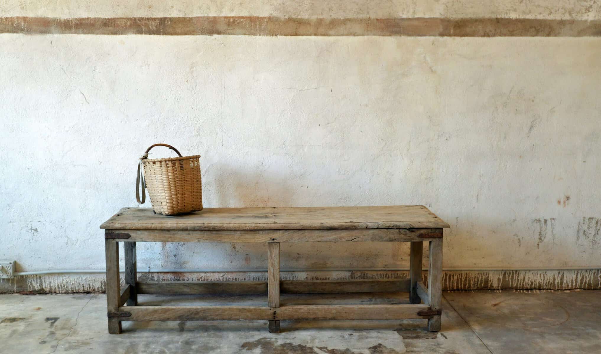 Long antique wooden farm table with a basket on top at Carol Hicks Bolton Antiquites in Fredericksburg