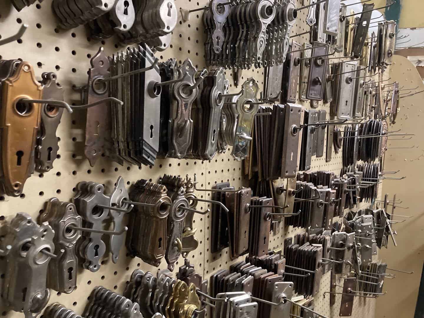 Pegboard wall of antique keyholes, backplates and door hardware at Old Home Supply House in Fort Worth