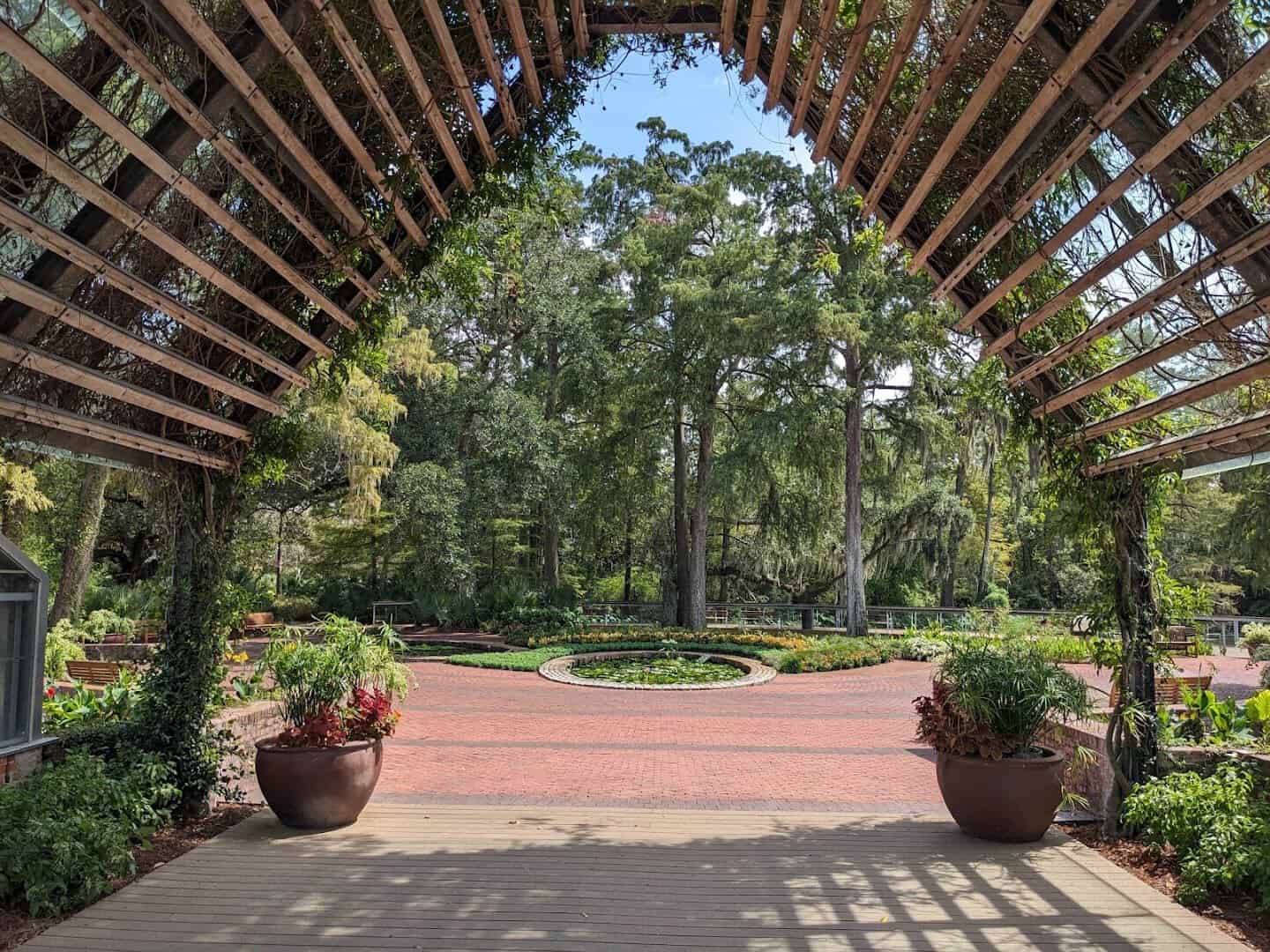 Arbor walkway lined with potted plants at Shangri La Botanical Gardens in Orange, Texas