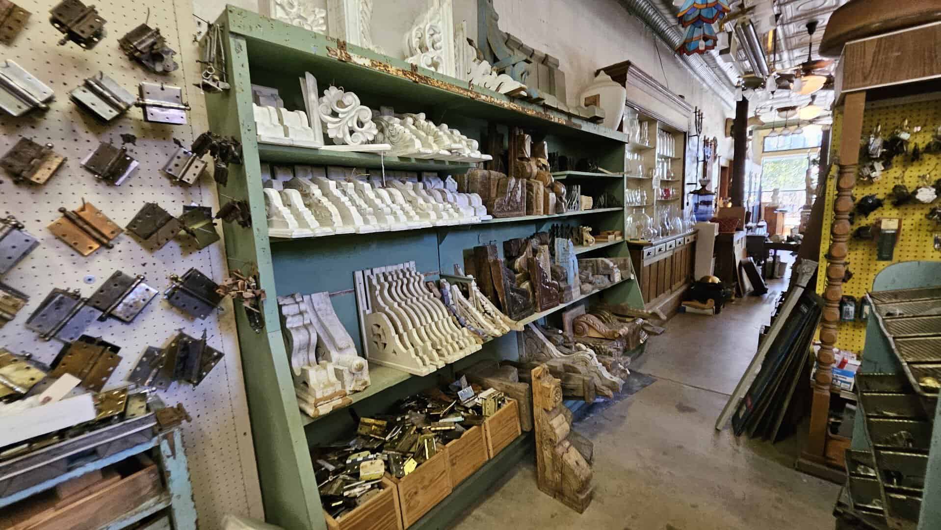Green shelves packed with salvaged architectural hardware and tin at Old Home Supply House in Fort Worth