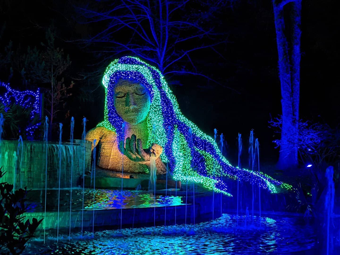 The earth goddess sculpture wrapped in blue holiday lights at the Atlanta Botanical Garden, Atlanta, Georgia