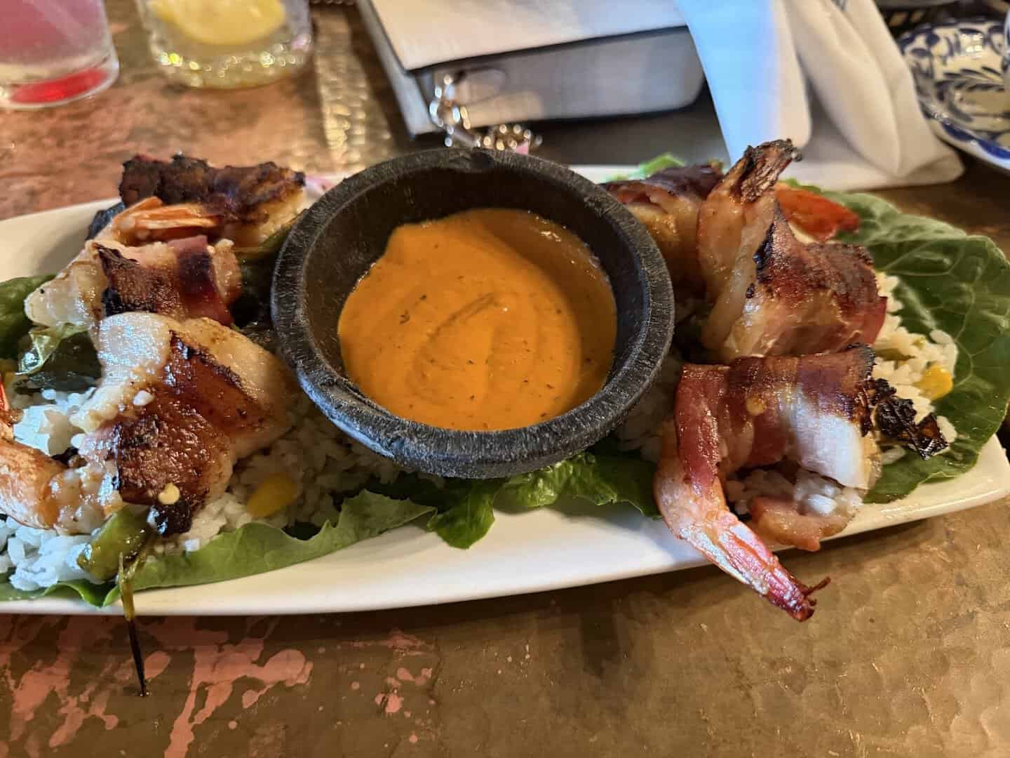 Bacon-wrapped grilled shrimp over rice with chipotle sauce at Mi Familia at the Rim in San Antonio