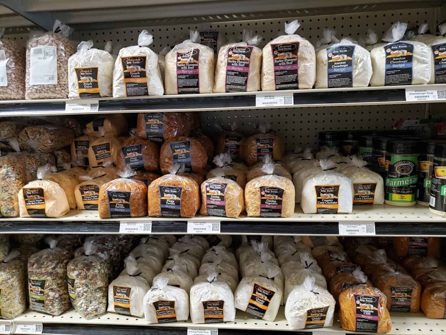 Bagged homemade bread loaves and bulk snack mixes on a shelf at Olde Towne Country Store in Itasca Texas