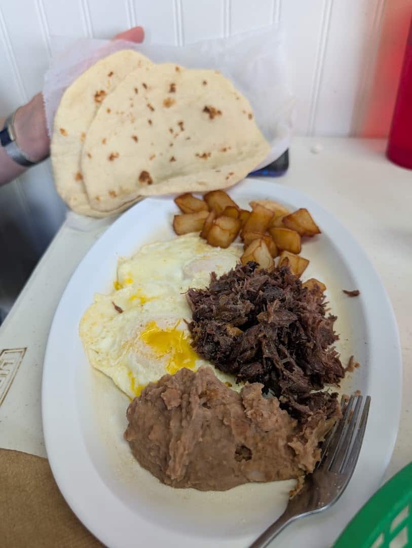 Barbacoa plate with eggs and a basket of homemade flour tortillas at Southside Barbacoa in Corpus Christi