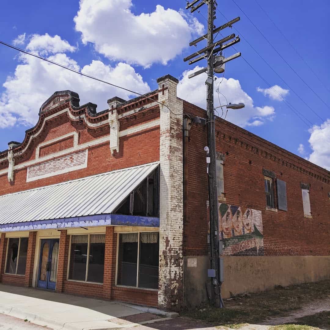 Historic brick storefront with a metal awning on the corner of East Clark Street in Bartlett Texas