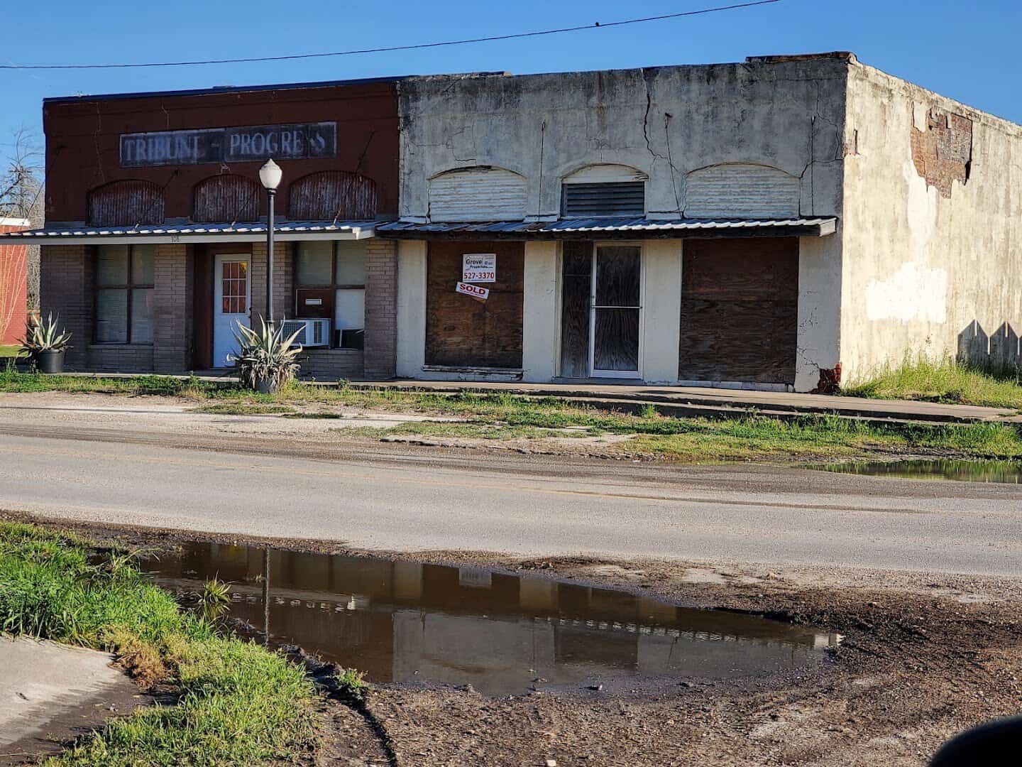 Red brick paving and a row of early 1900s storefronts on East Clark Street in Bartlett Texas