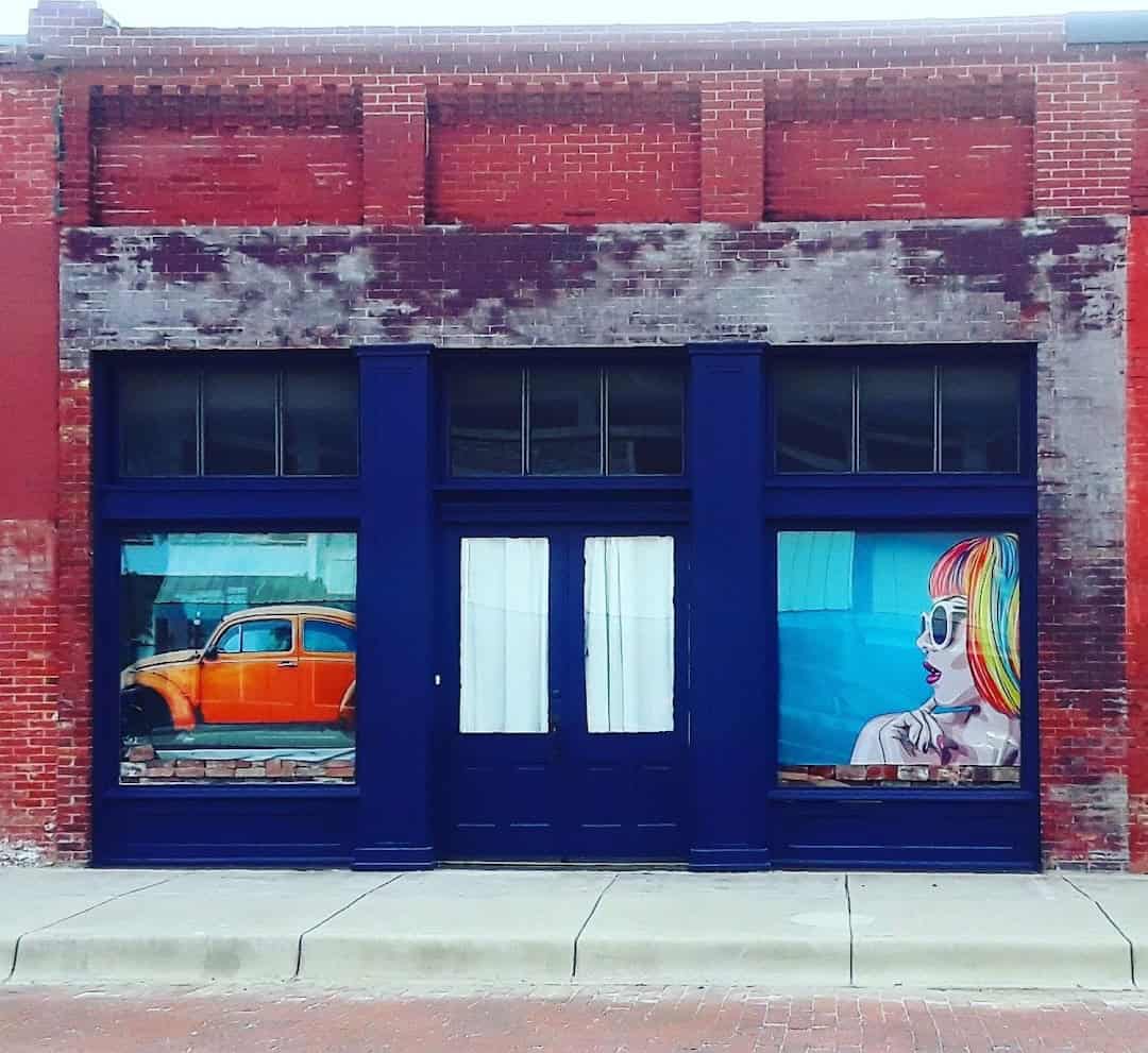 Restored brick storefront on Clark Street with art in the windows in Bartlett Texas