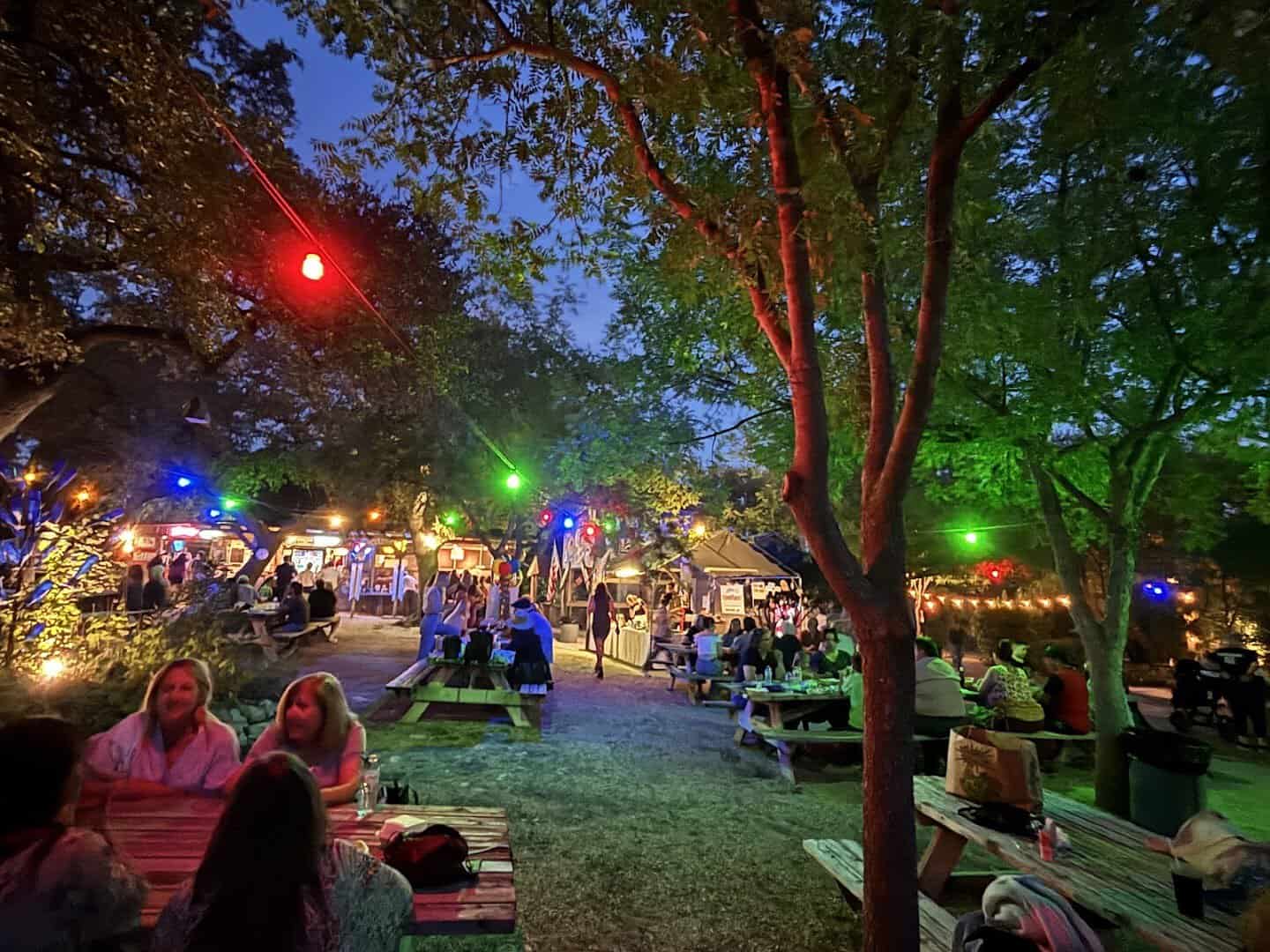 Biergarten at night with string lights under the oaks at Walburg German Restaurant