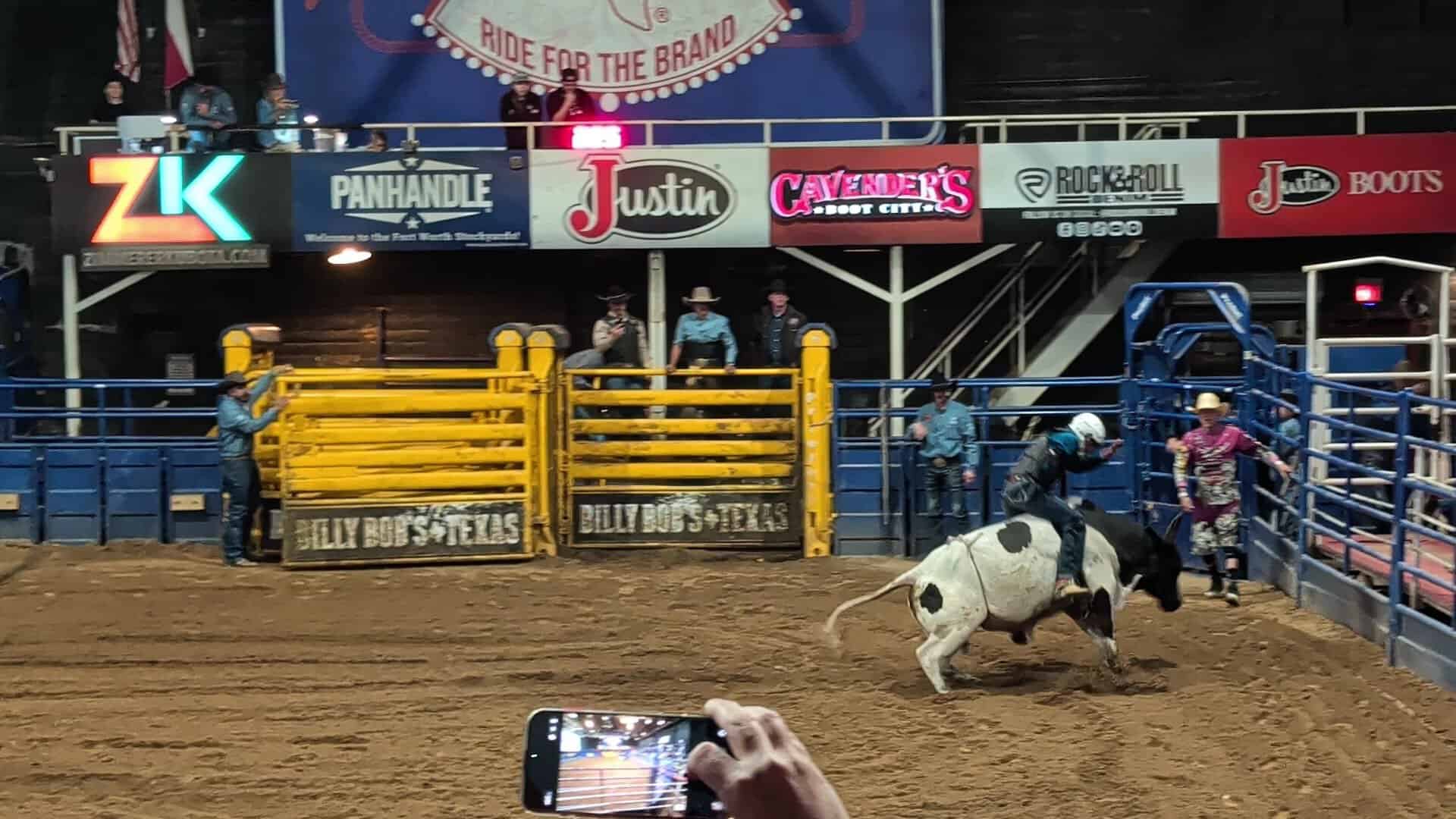 A cowboy riding a bucking bull in the arena at Billy Bob's Texas in Fort Worth
