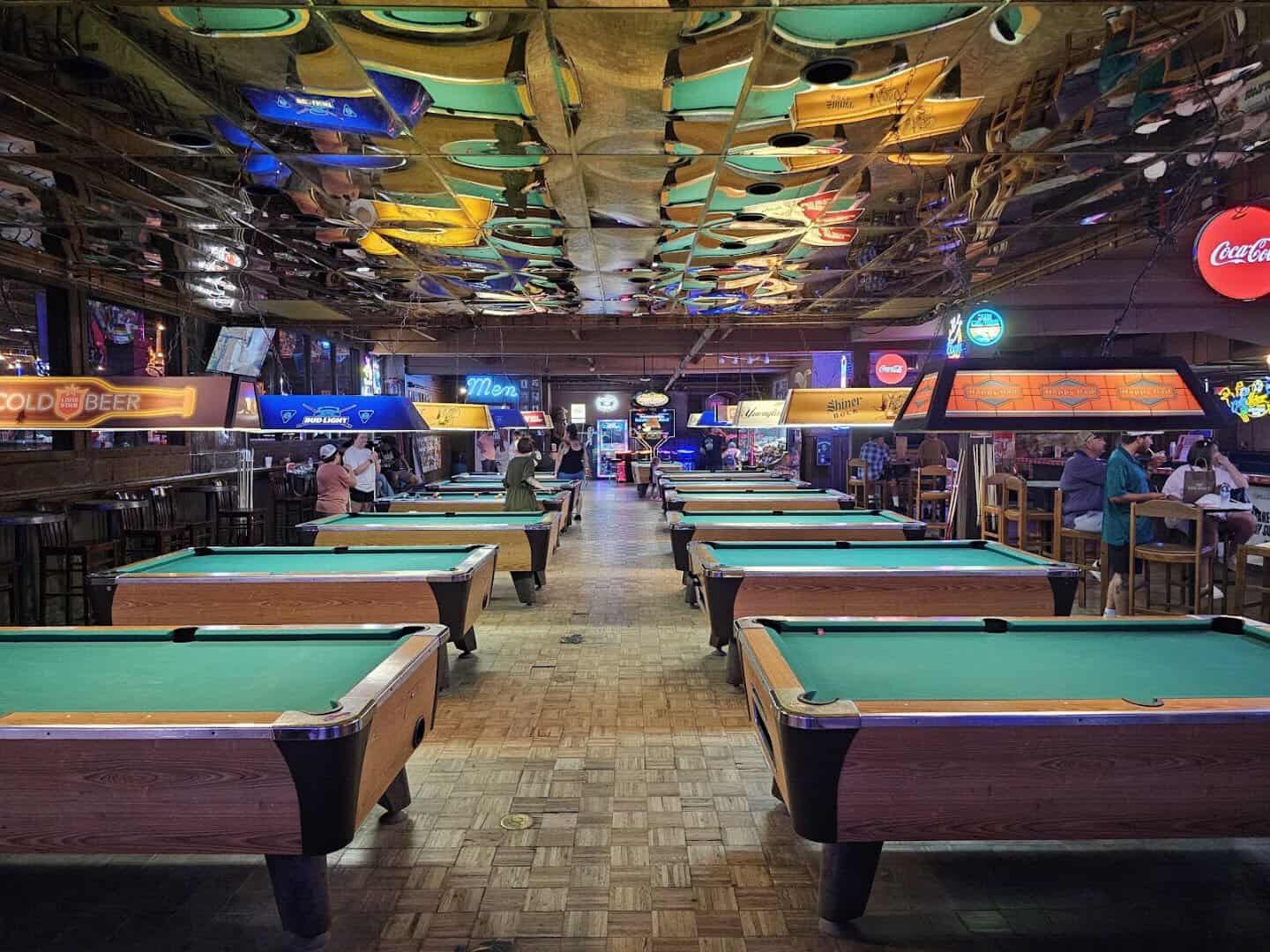 Rows of pool tables under neon lights inside Billy Bob's Texas in Fort Worth