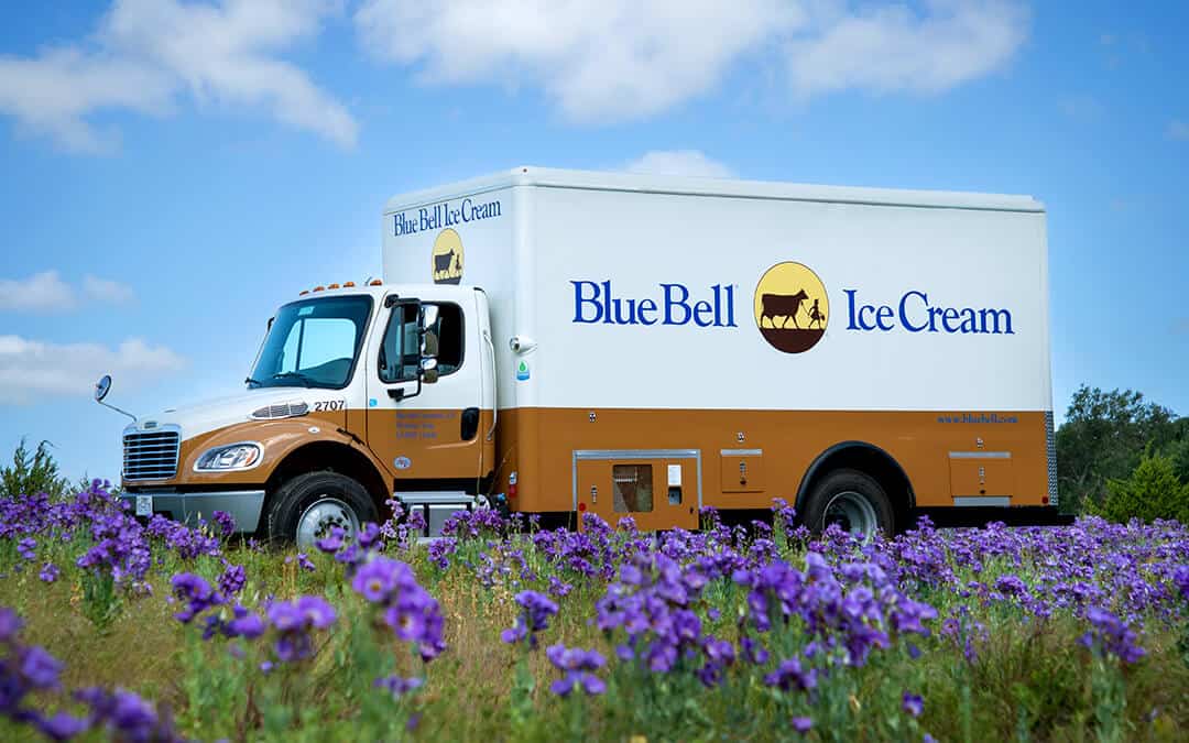 A Blue Bell ice cream delivery truck in a field of Texas wildflowers