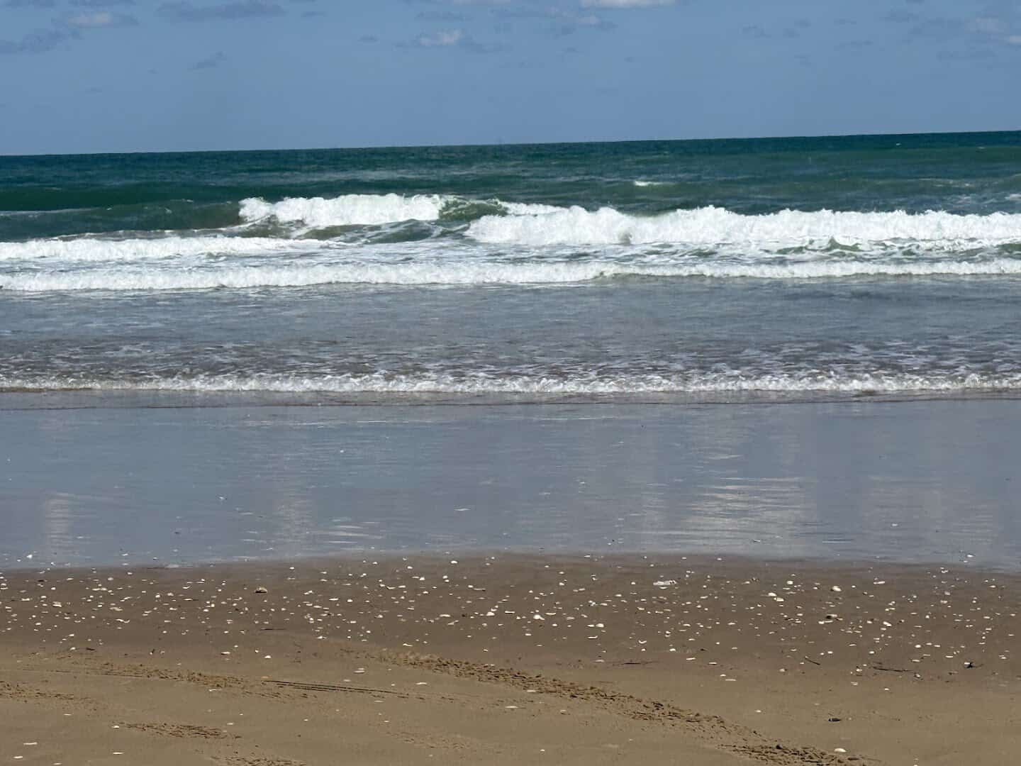 Gulf waves rolling onto the open sand at Boca Chica Beach, Texas