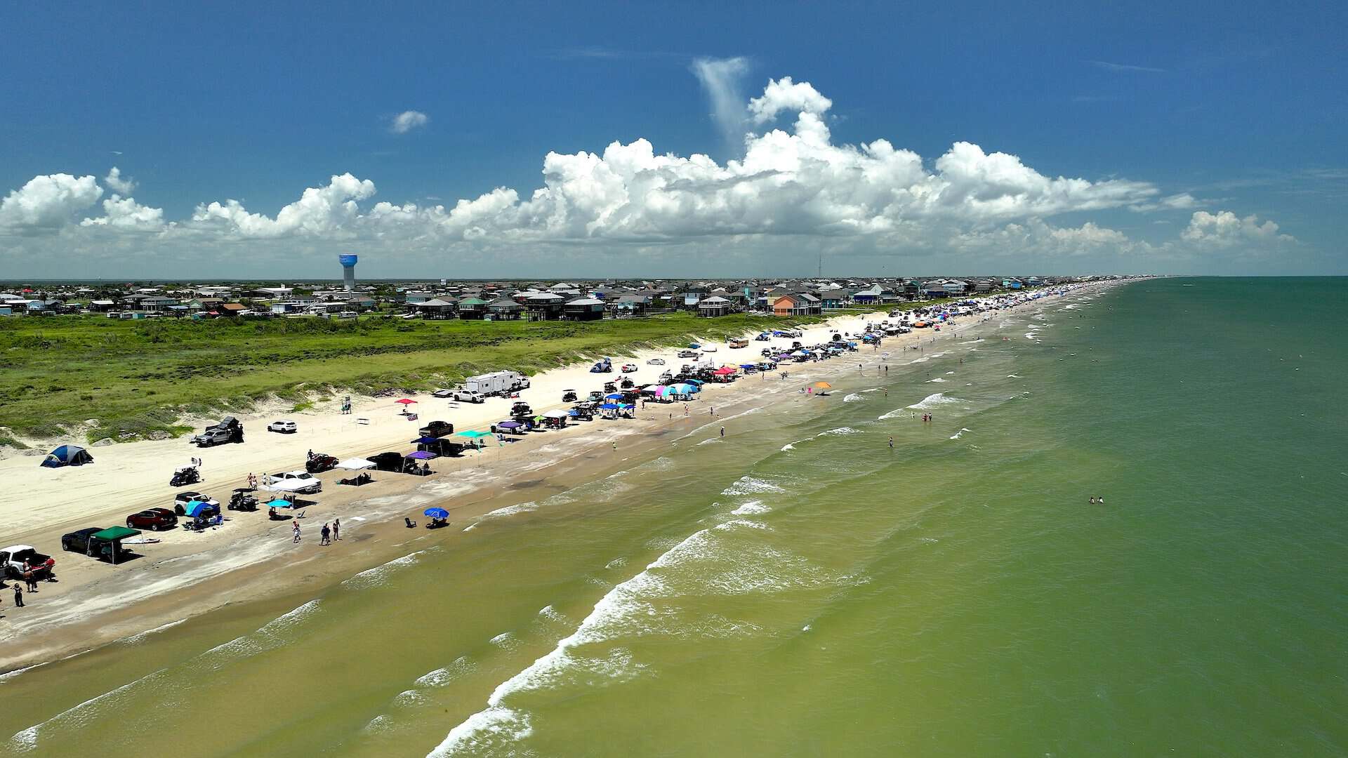 Aerial view of trucks and canopies lined along the drive on beach of the Bolivar Peninsula in Texas