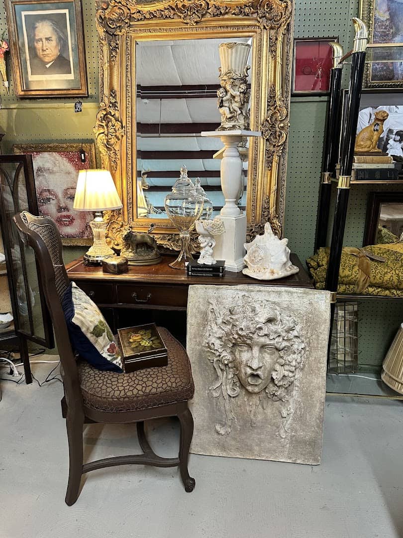 Booth vignette with a gilt mirror, writing desk and framed art at The Antique Gallery of Houston in Spring Texas
