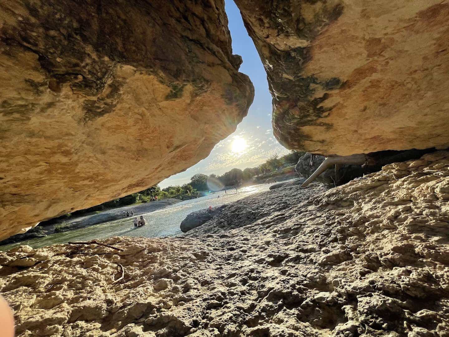 Water pooled beneath a large limestone boulder overhang at Big Rocks Park in Glen Rose, Texas
