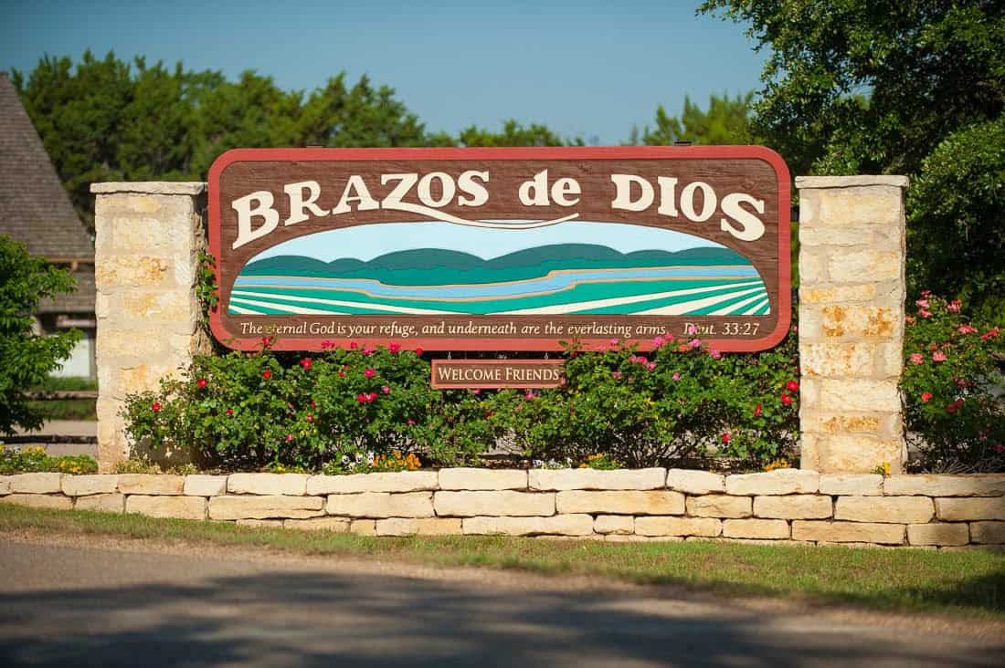 Brazos de Dios welcome sign at the entrance to Homestead Heritage near Waco, Texas