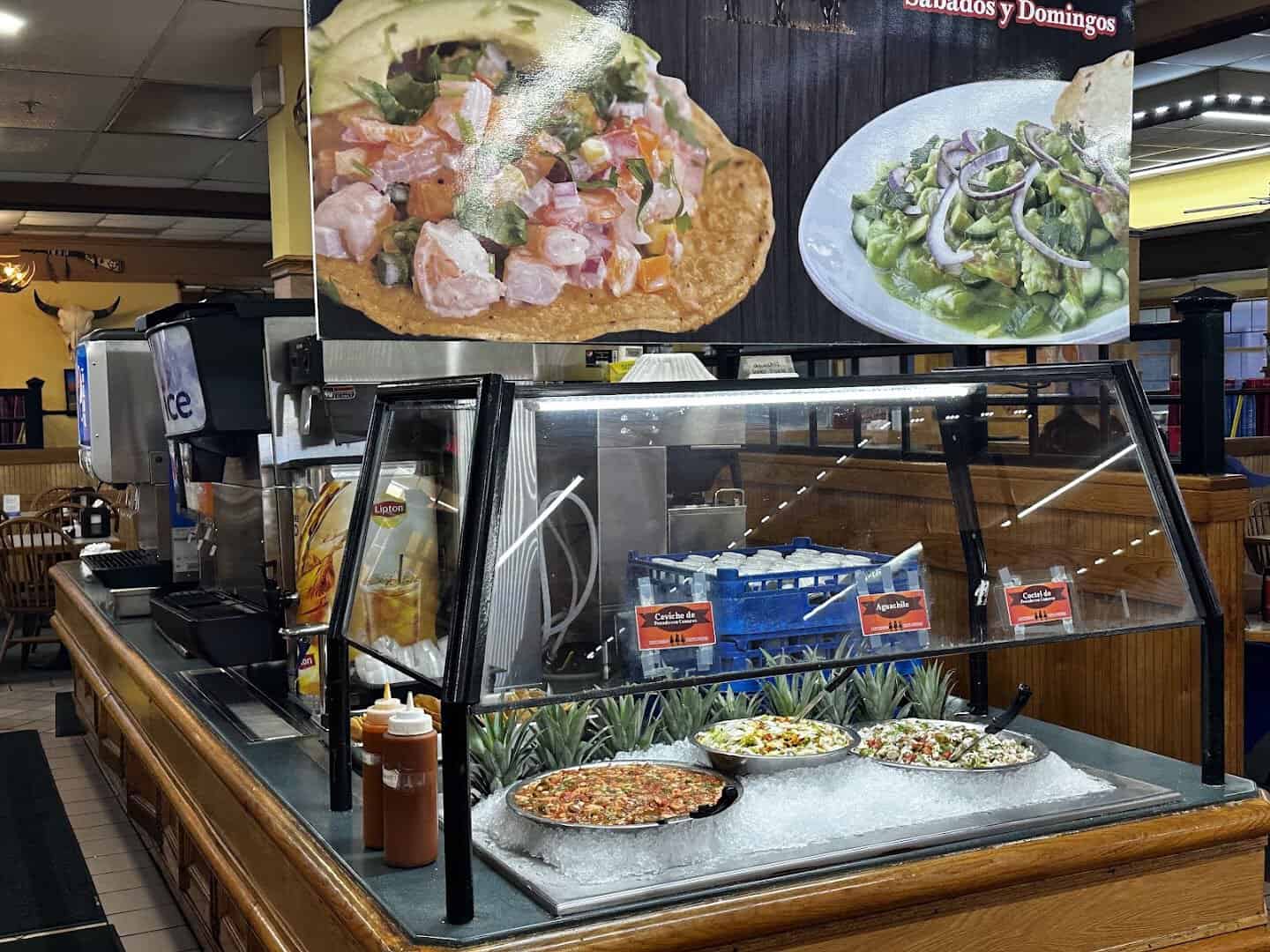 Trays of ceviche, tostadas and dishes on the buffet line at Ranchero King Buffet in Houston