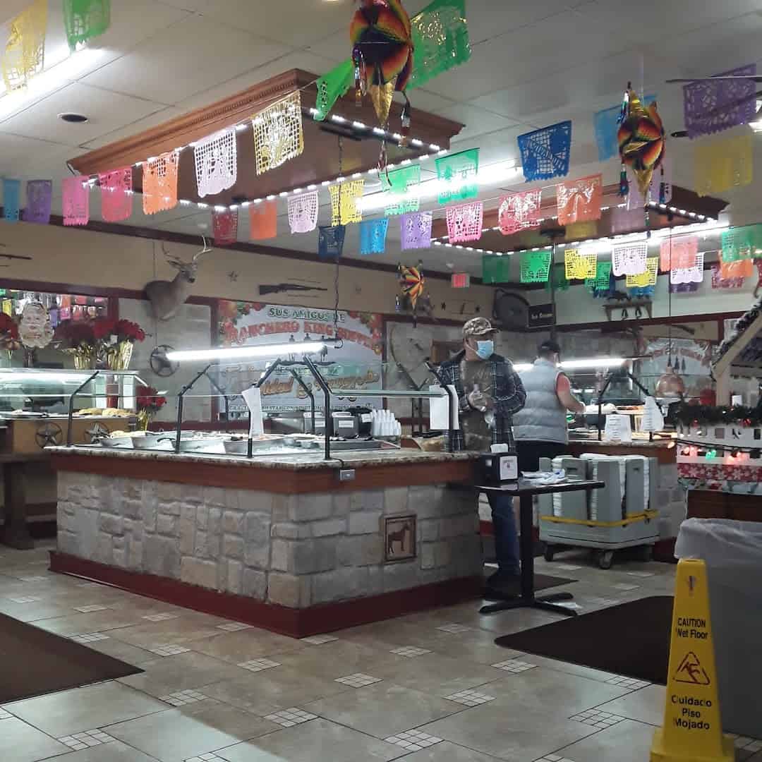 Buffet line under papel picado banners at Ranchero King Buffet in Houston
