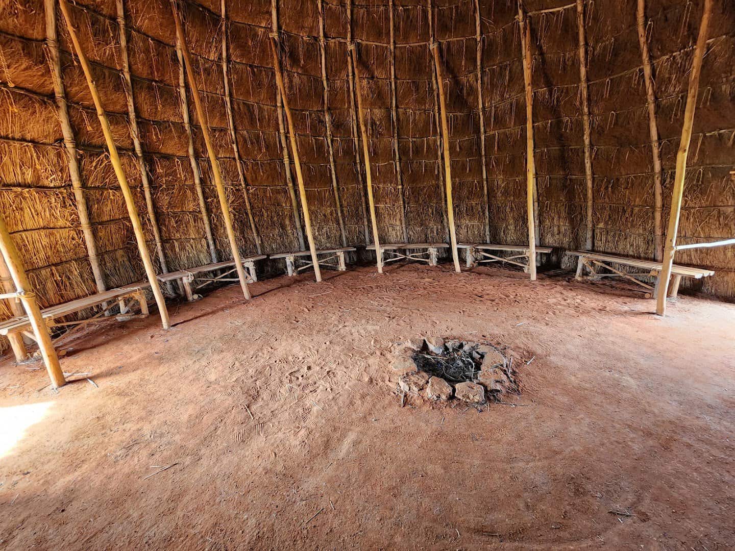 Interior of the reconstructed Caddo grass house with central fire pit at Caddo Mounds