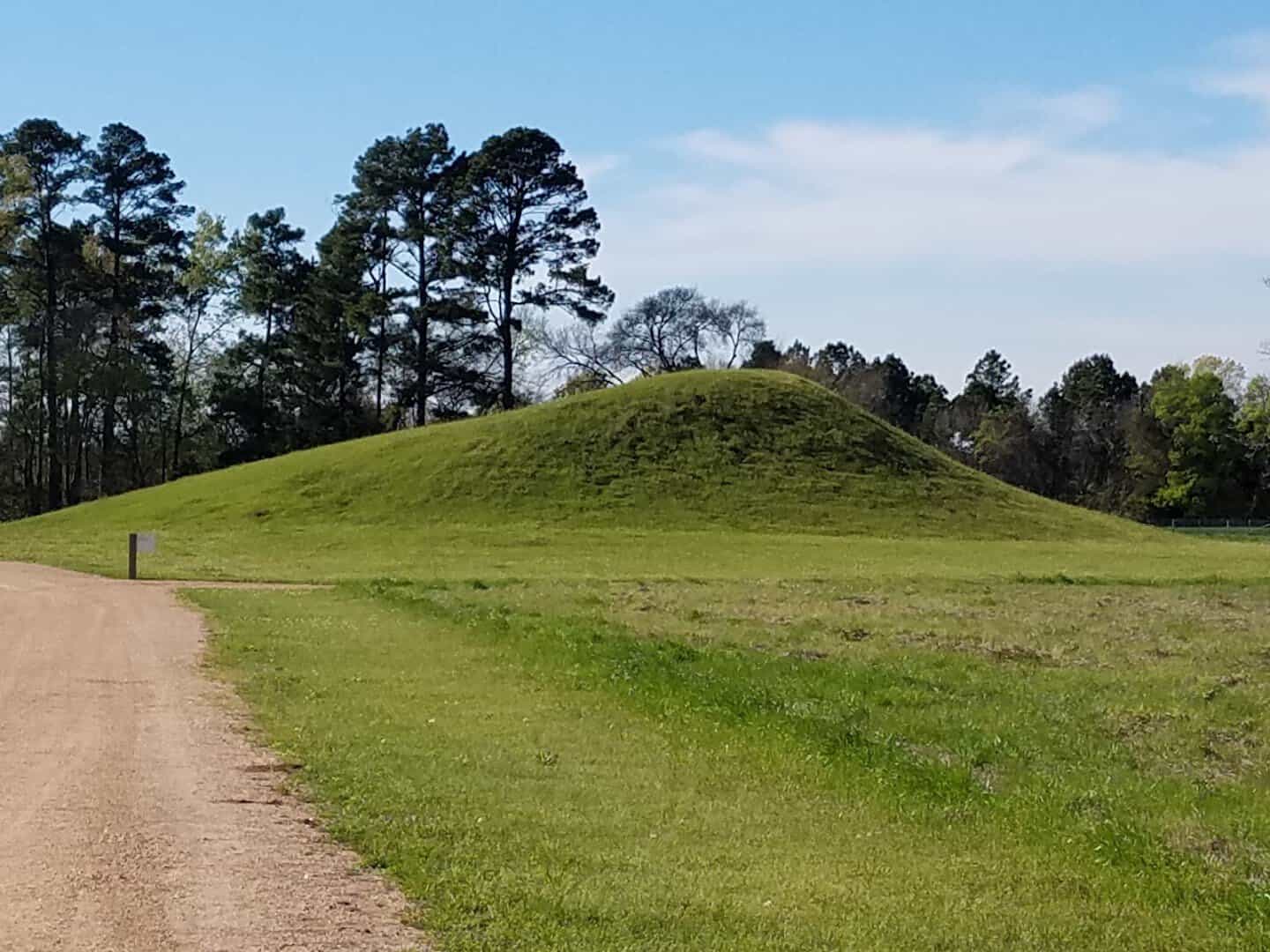 Green earthen mound rising from the field at Caddo Mounds State Historic Site near Alto, Texas