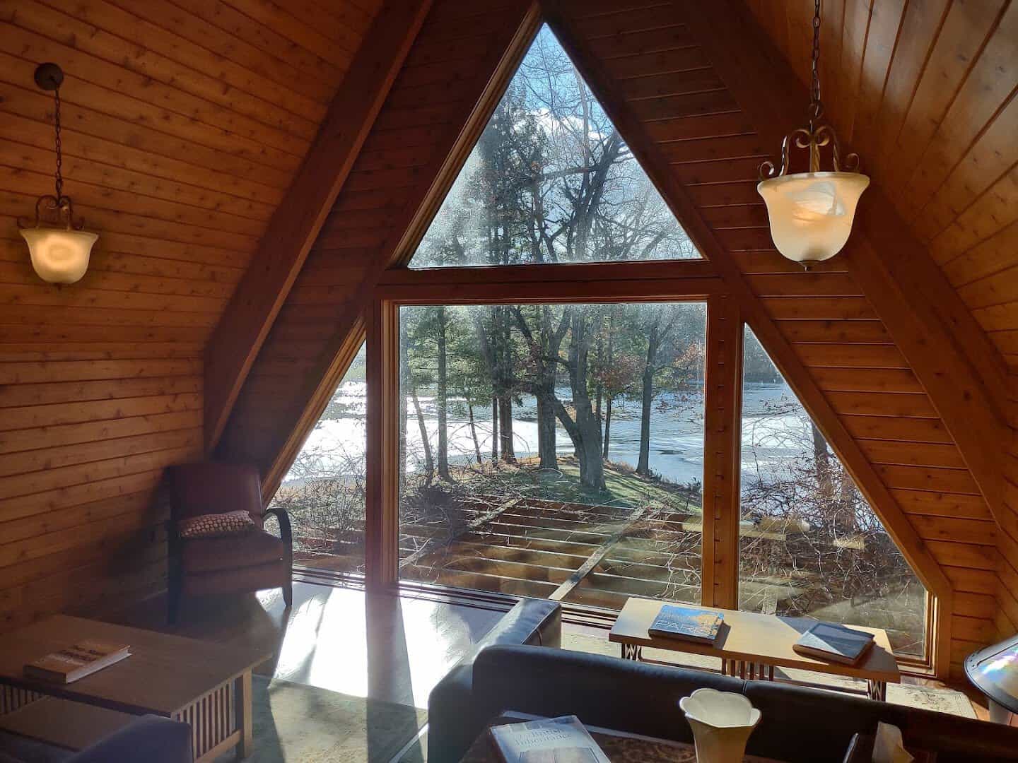 A cozy A-frame cabin interior with warm wood and forest views at Canoe Bay, Chetek, Wisconsin