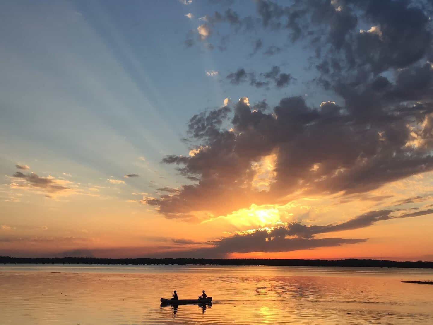 Paddlers in a canoe at sunset on B.A. Steinhagen Reservoir at Martin Dies Jr State Park