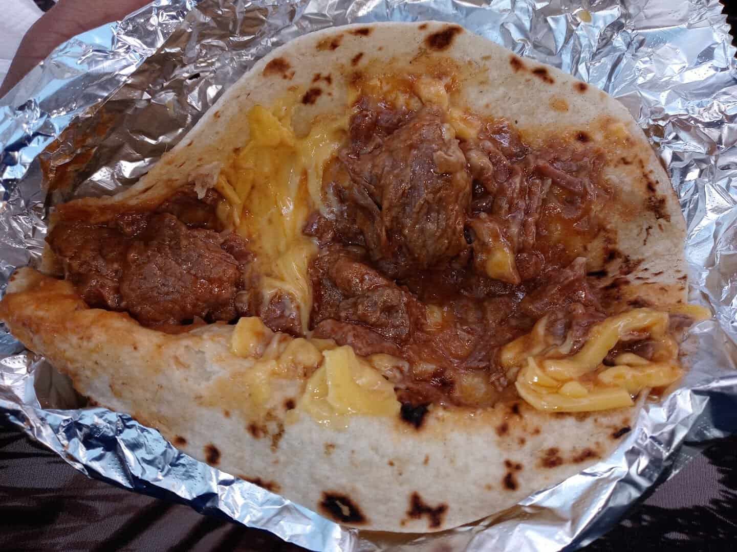 Carne guisada taco with melted cheese in a flour tortilla at Southside Barbacoa in Corpus Christi