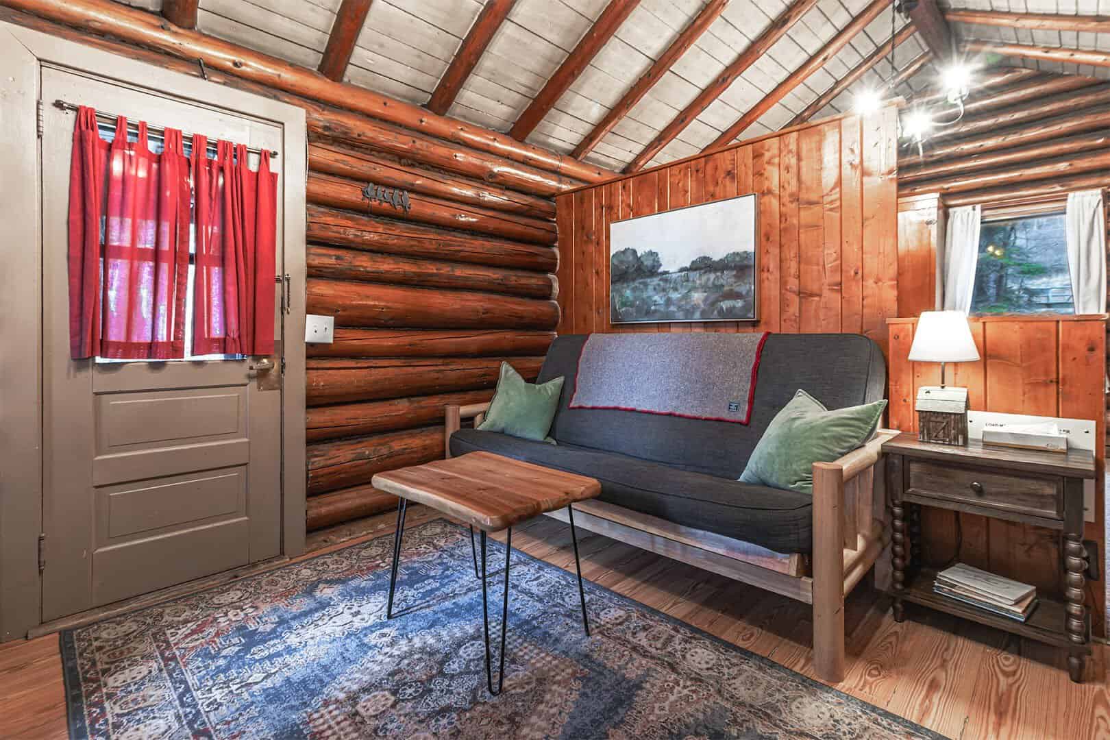 Cozy log-walled cabin interior with red curtains and a sofa, Cascade Lodge, Lutsen, Minnesota