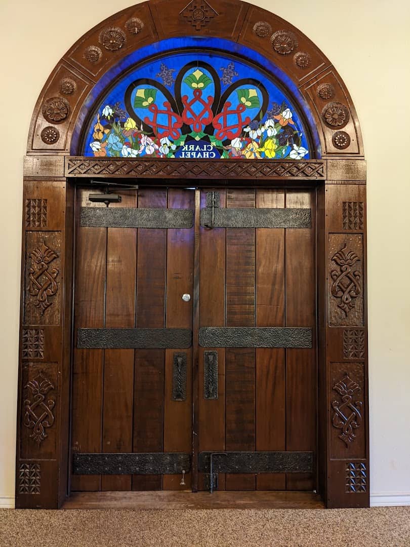 Carved wooden doors and stained glass of the sandstone chapel at Clark Gardens in Weatherford, Texas