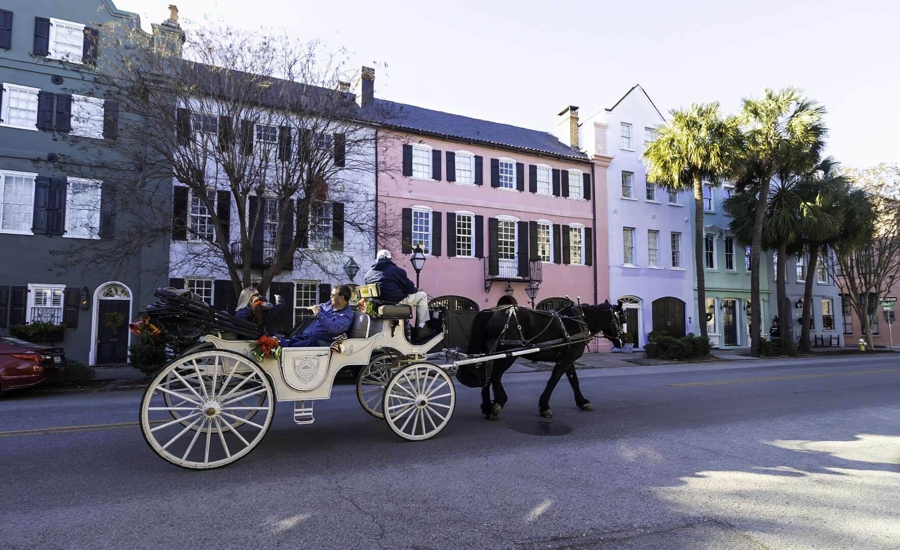 Pastel historic houses and a horse carriage on Rainbow Row in Charleston, South Carolina