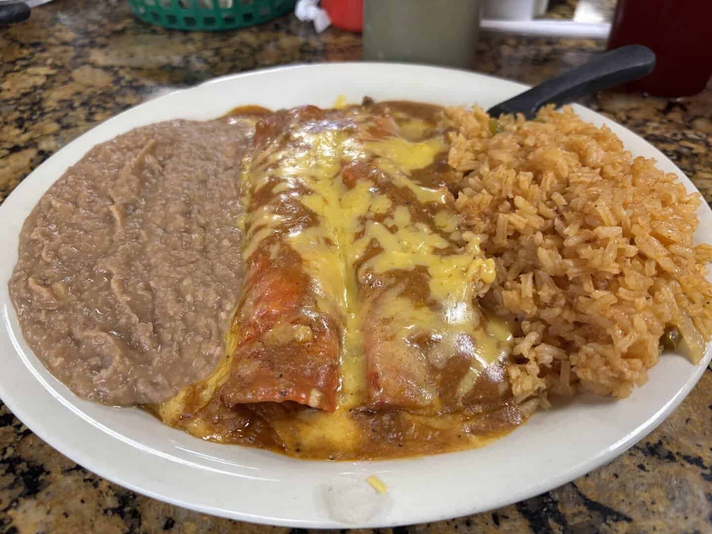 Cheese enchiladas smothered in chili gravy with rice and refried beans at Eddie's Taco House in San Antonio