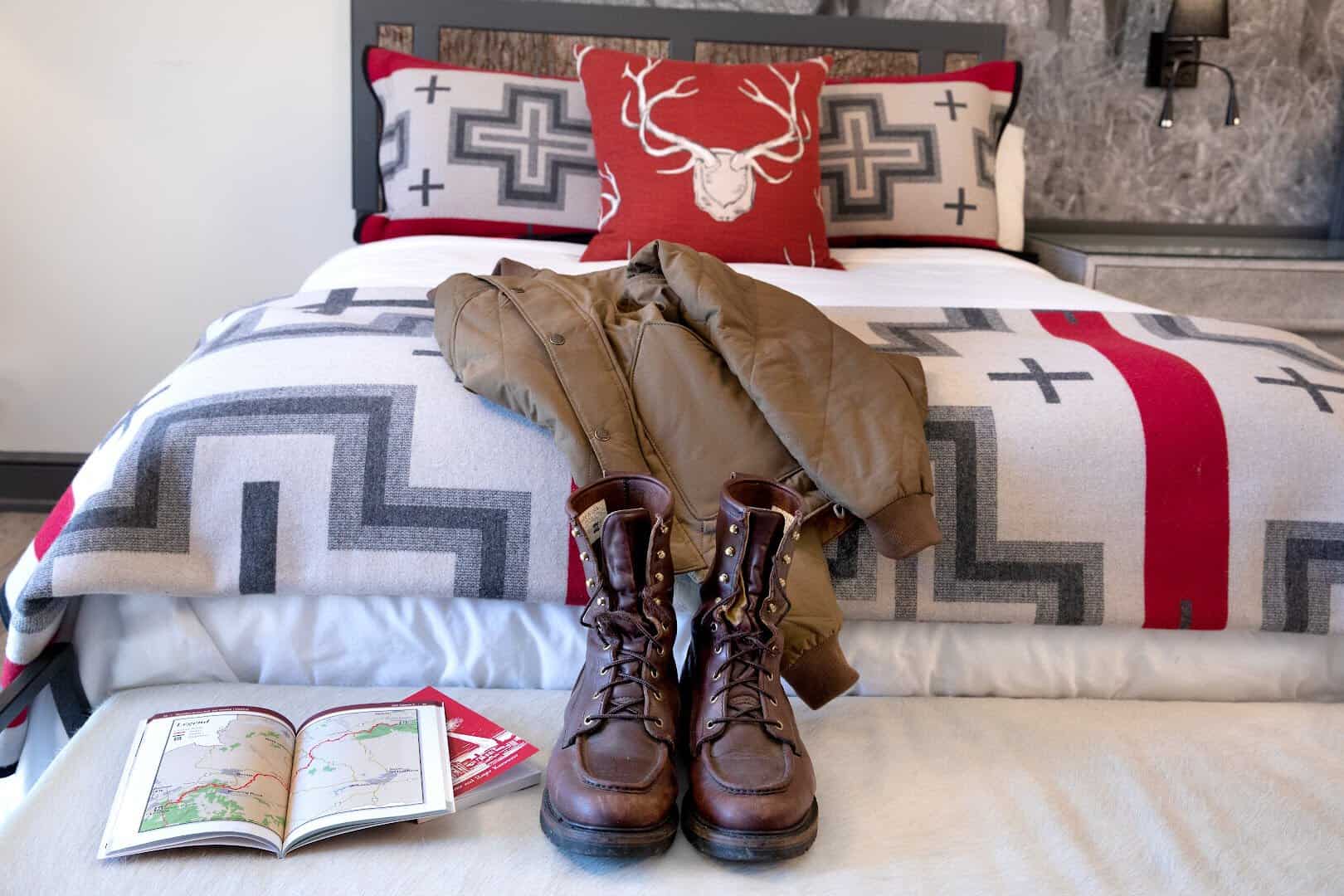 Cozy bed with red festive blanket and hiking boots, Chetola Resort, Blowing Rock, North Carolina