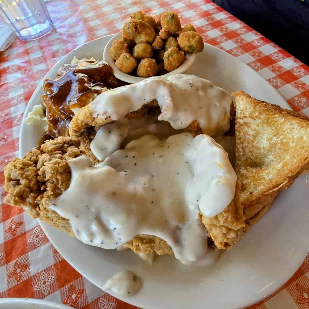 Close up of chicken fried steak under cream gravy with fried okra and Texas toast at Richter's Antler Cafe in Spring Branch