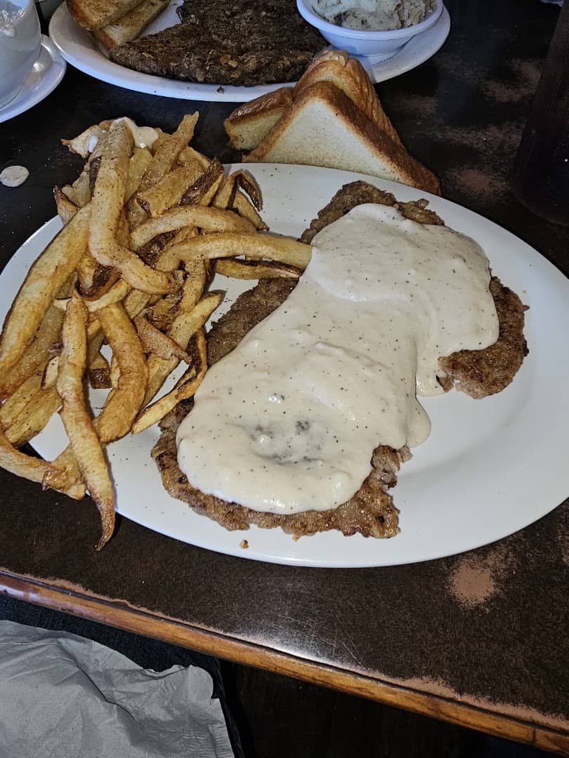 Chicken fried steak smothered in cream gravy with hand-cut fries at Mary's Cafe in Strawn, Texas