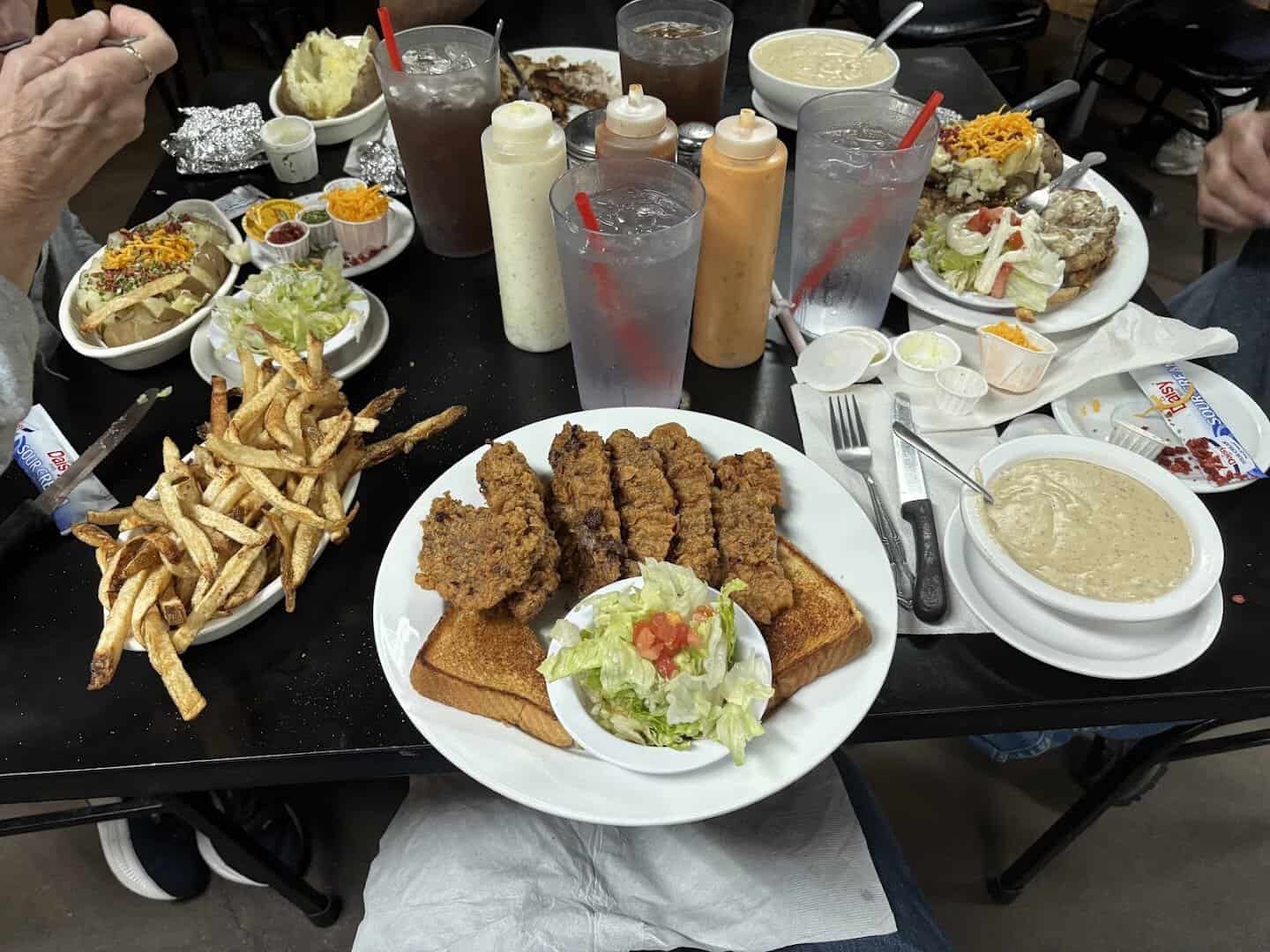 A table spread of chicken fried steak strips, hand-cut fries and sides at Mary's Cafe in Strawn, Texas