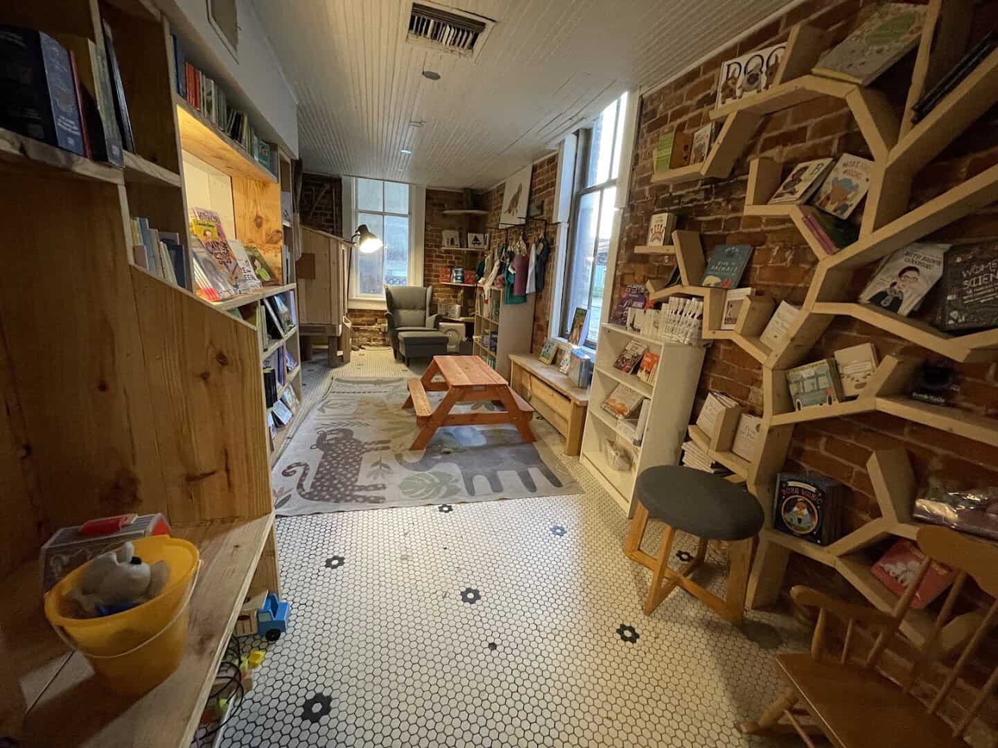 Children's reading nook with a picnic table and honeycomb shelves at The Painted Porch Bookshop in Bastrop, Texas