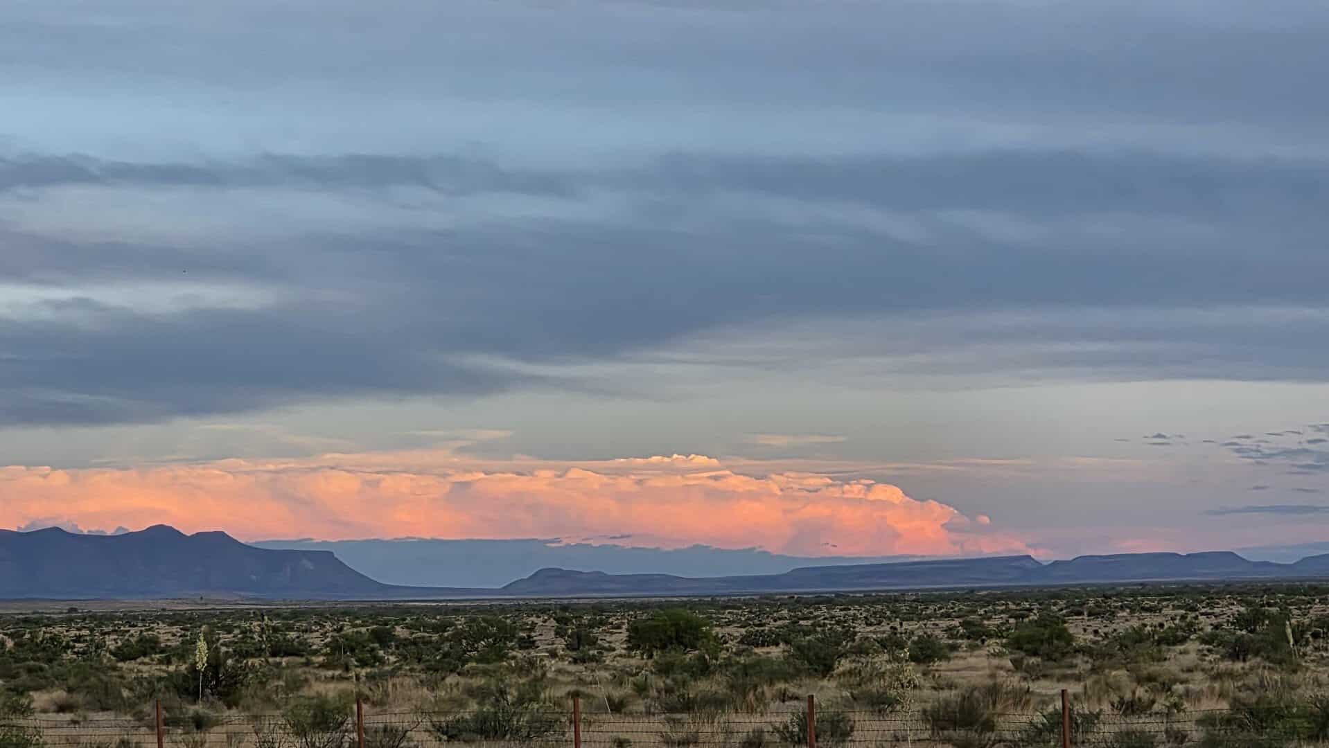 Pink dusk light over the Chinati Mountains and desert plain near Marfa