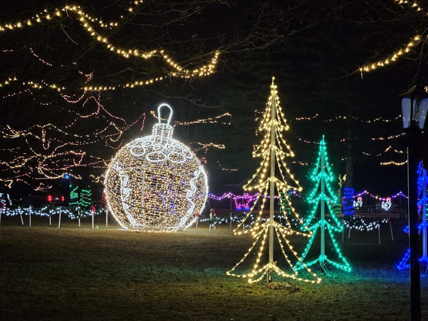 A giant lit ornament and light-up trees at Crossroads Village, Flint, Michigan