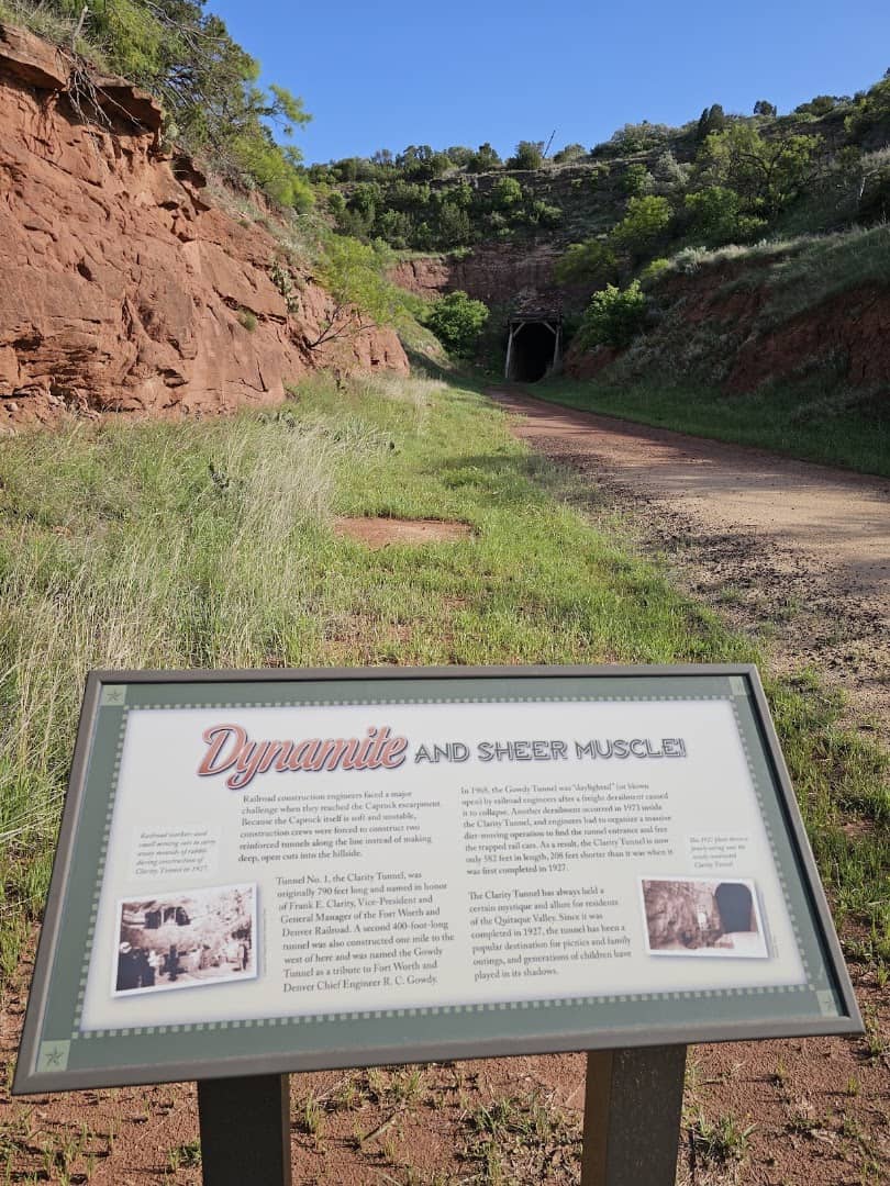 Trail leading up to the dark entrance of Clarity Tunnel in the red rock, Caprock Canyons, Texas