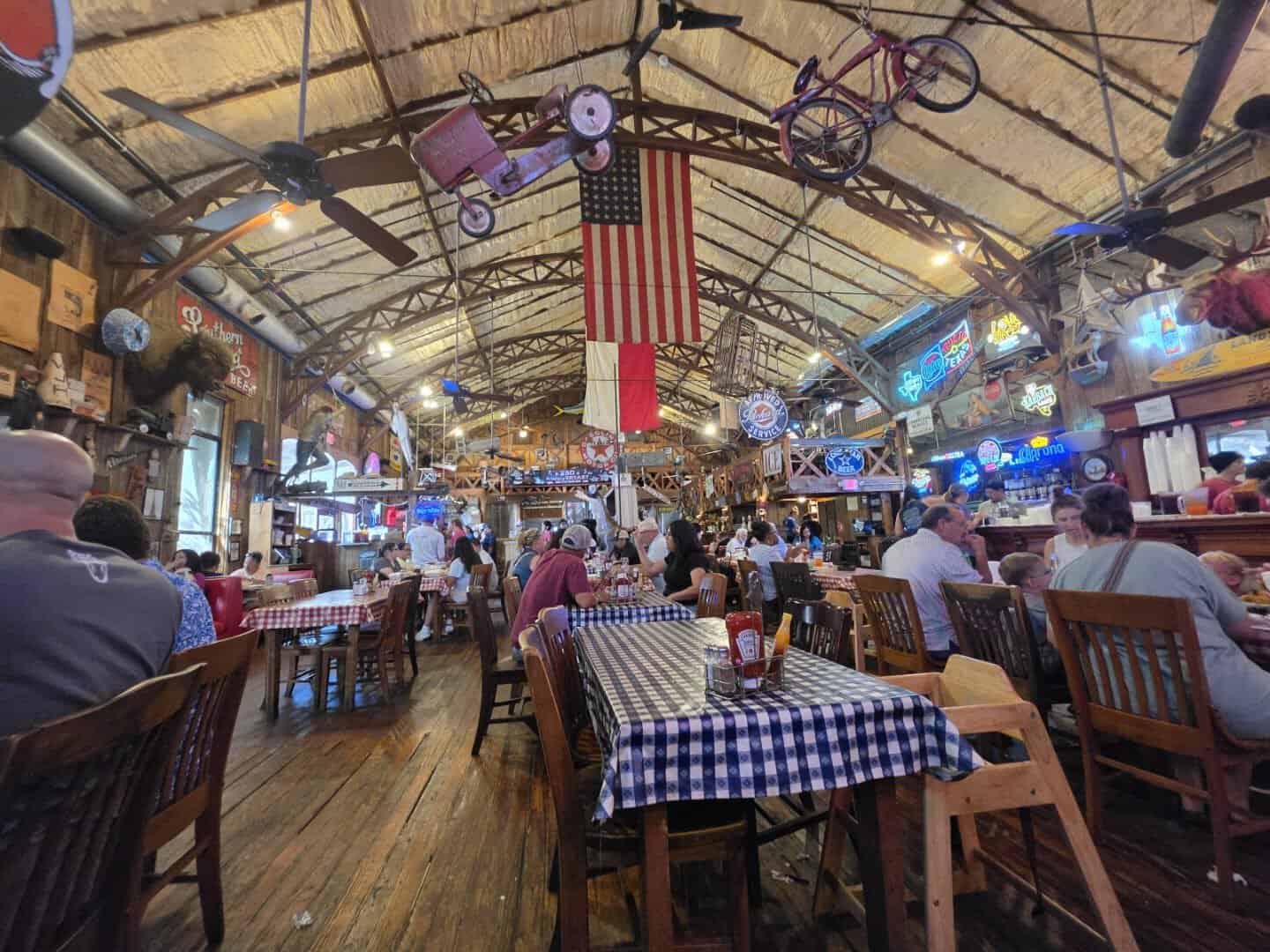 The grand vaulted historic dining hall with flags at Clear Springs Restaurant in New Braunfels