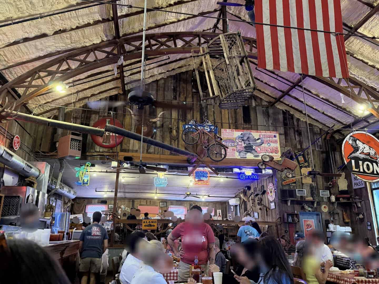 The rustic barn interior with neon signs and vintage decor at Clear Springs Restaurant