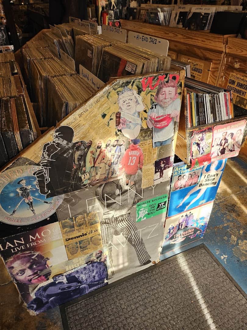 Collaged record crate in front of rows of used vinyl at Sigs Lagoon in Houston