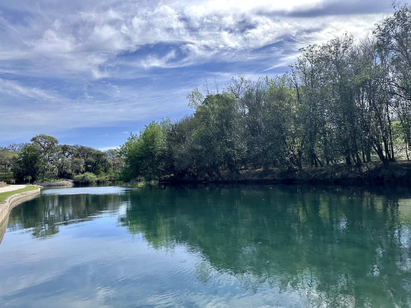 Wide view of the Comal River under a dramatic sky at Hinman Island Park in New Braunfels